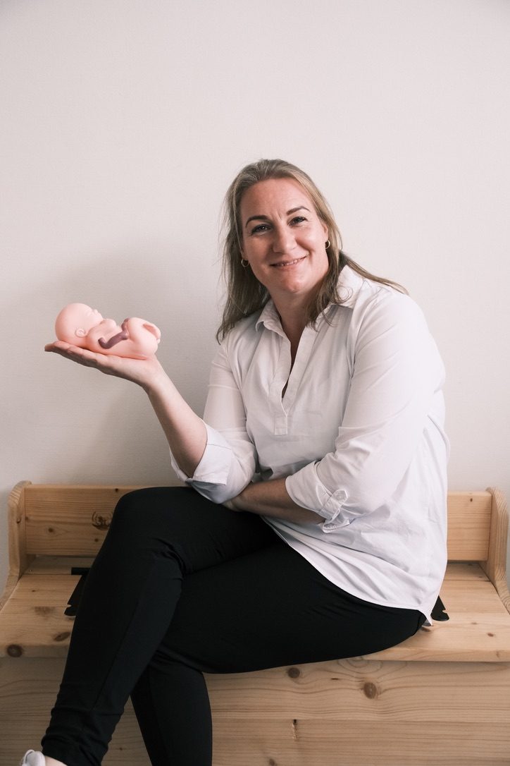 Vrouw met een babypoppetje in haar hand
